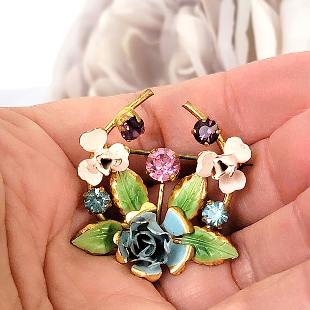 Vintage dainty flower brooch in hand.