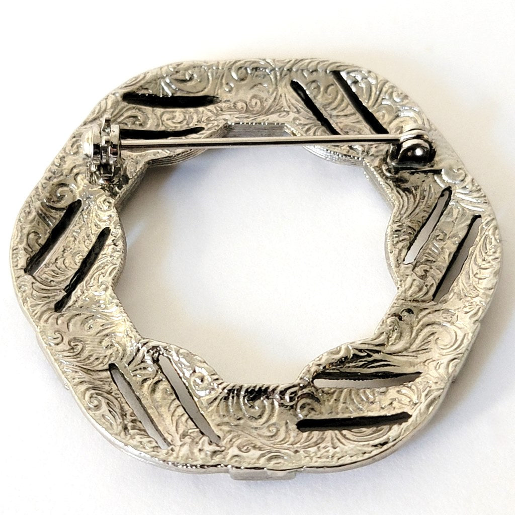 Designer swirl pattern on the back of a brooch.
