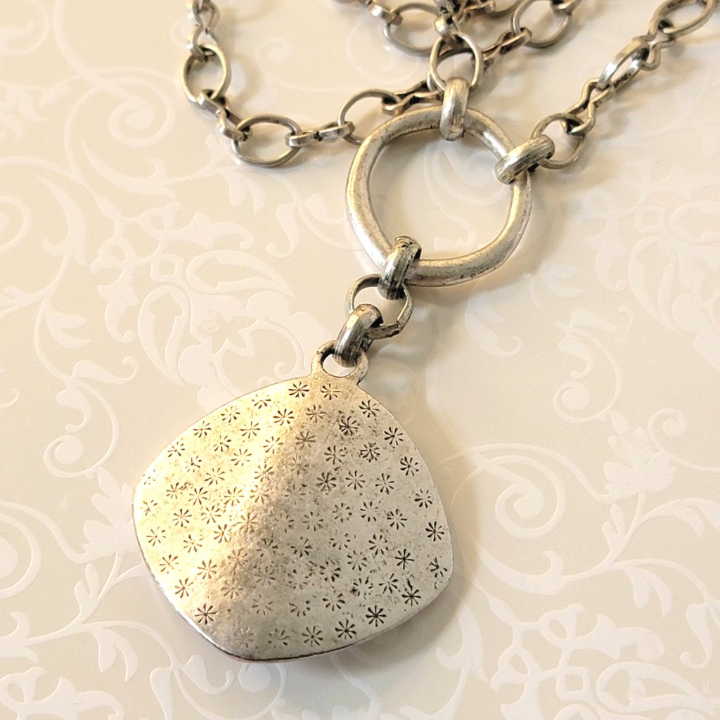 Back view of an antiqued silver tone pendant, by Premier Designs.