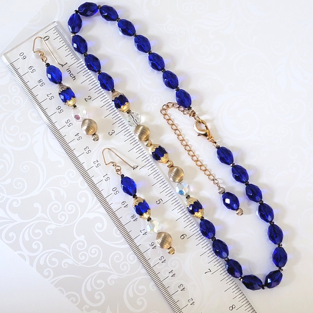 Handmade blue glass necklace and earrings jewelry set, shown next to a ruler.