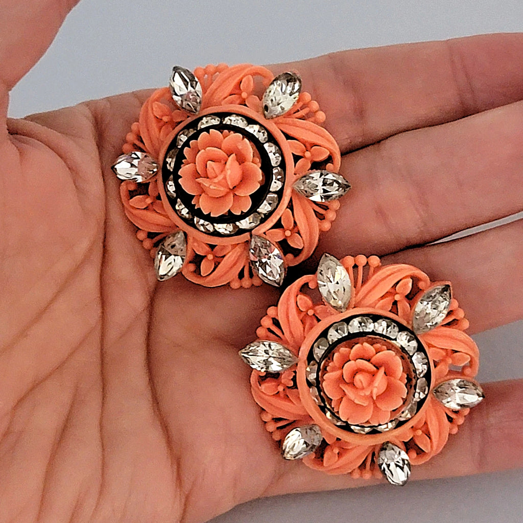 Vintage celluloid earrings in hand.