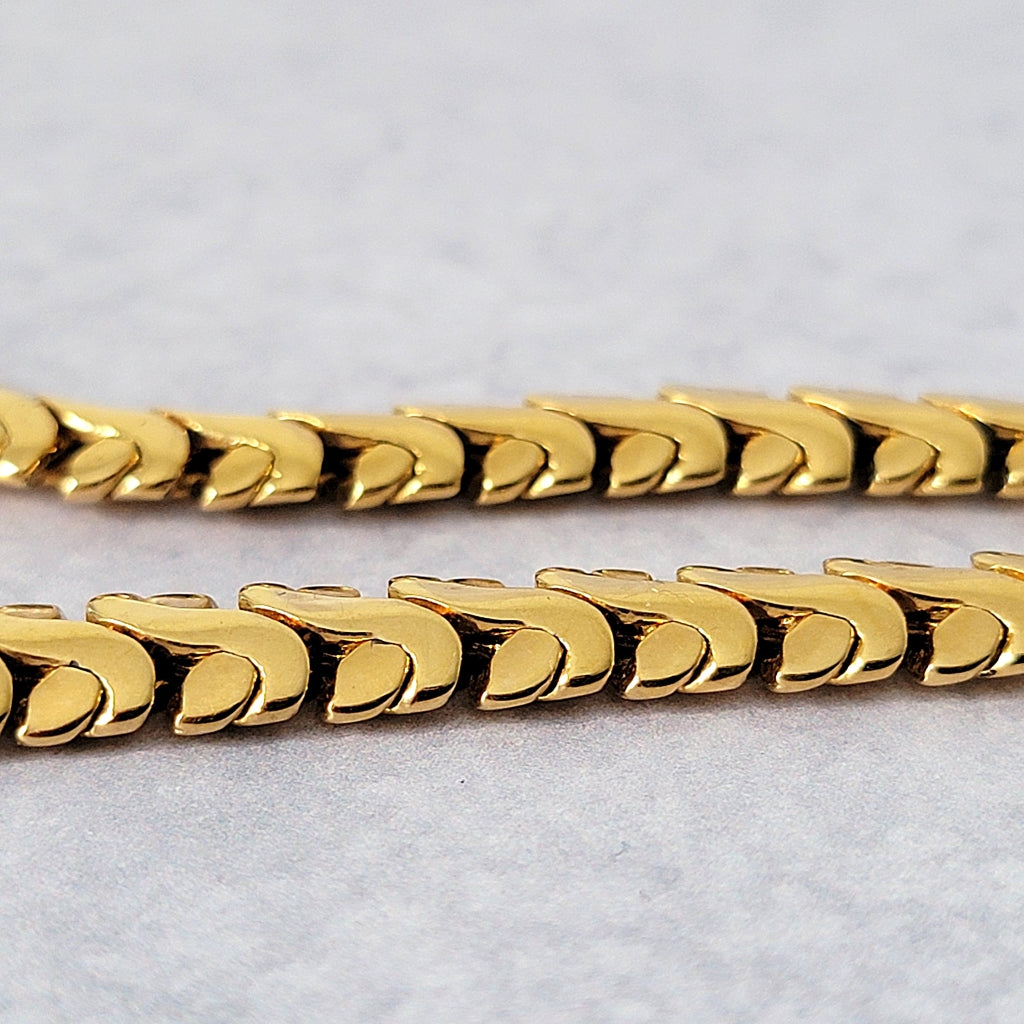 Detail of fancy thick, gold tone necklace links.