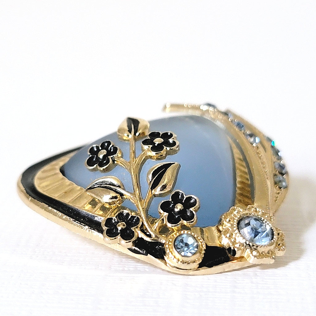 Detail of black enamel flowers on a vintage brooch.