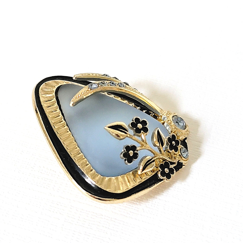 Black enamel and gold tone setting of a vintage pin.