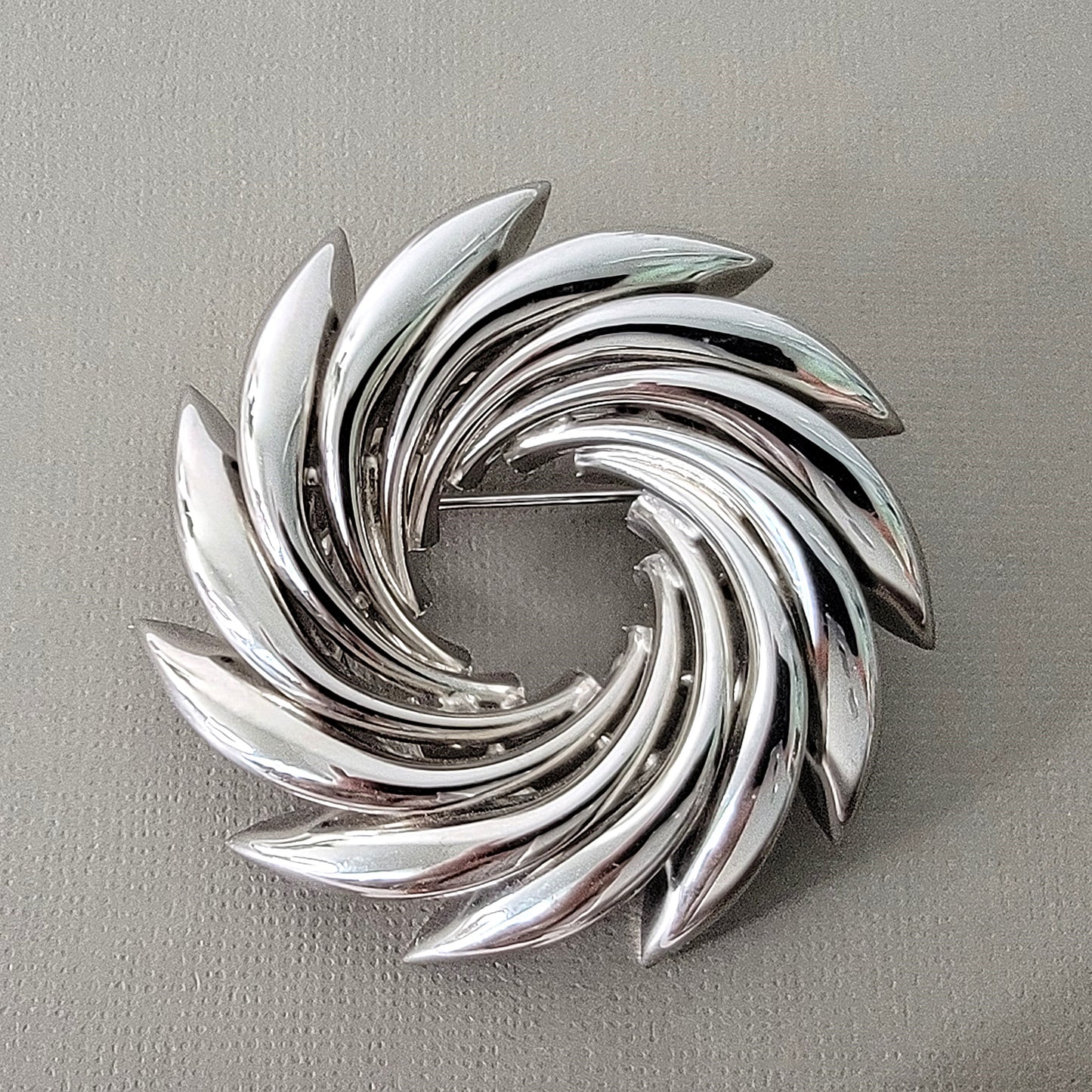 Silver tone midcentury style vortex shaped brooch.
