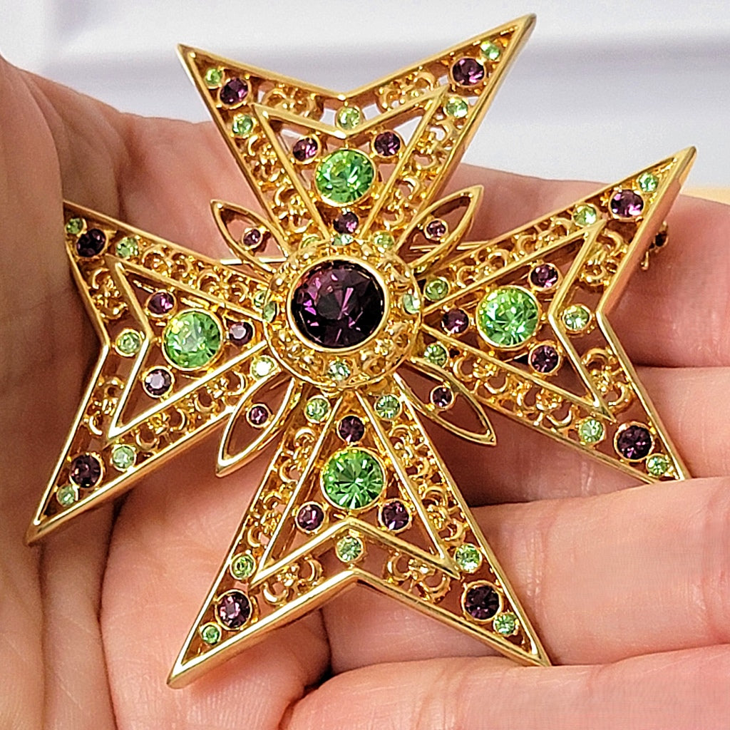 Rhinestone cross pin in hand.