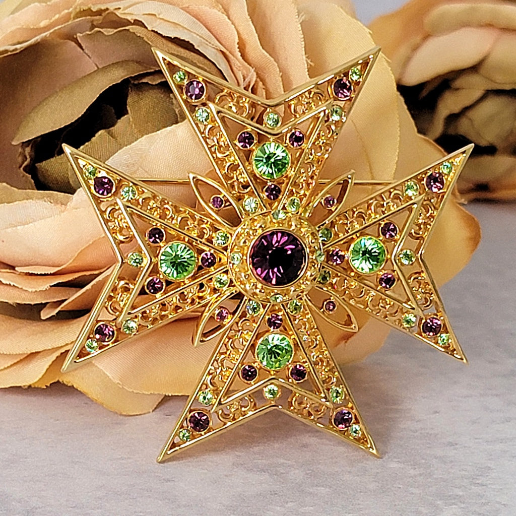Large gold purple and green rhinestone cross pin.