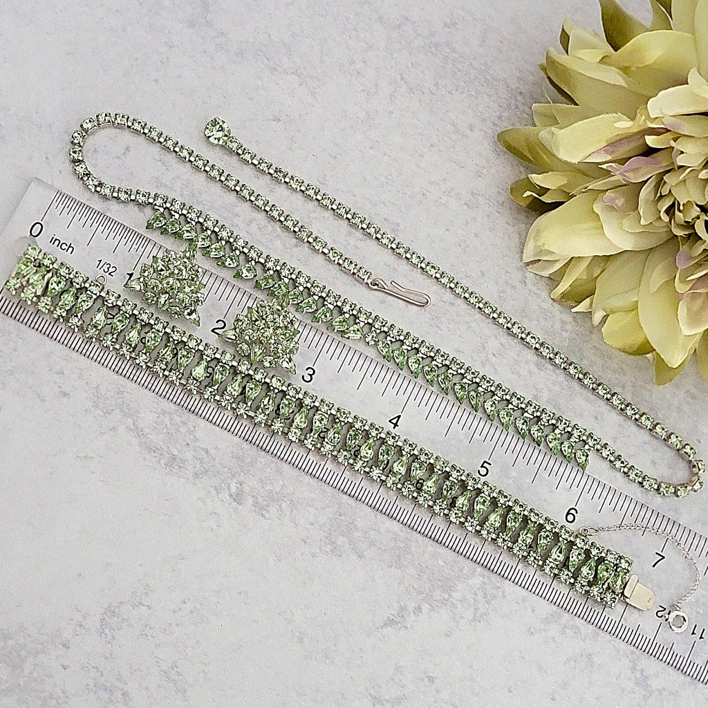 Vintage rhinestone jewelry set next to a ruler.
