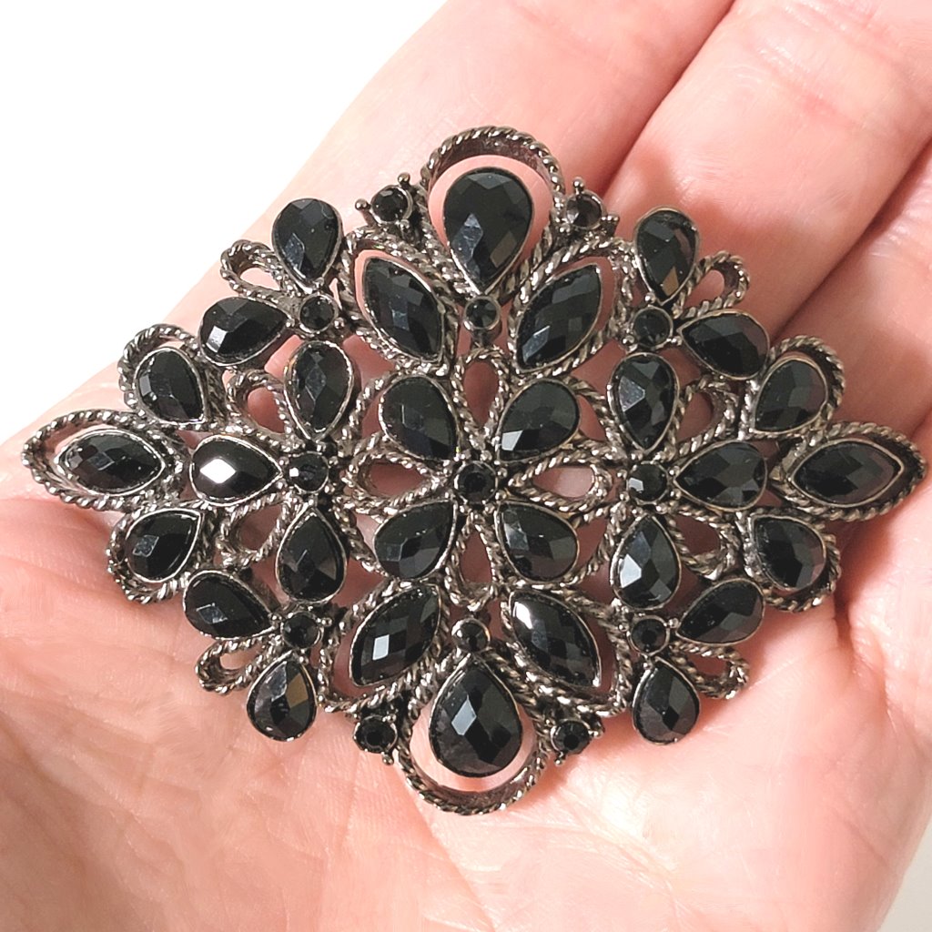 Black Monet brooch in hand.