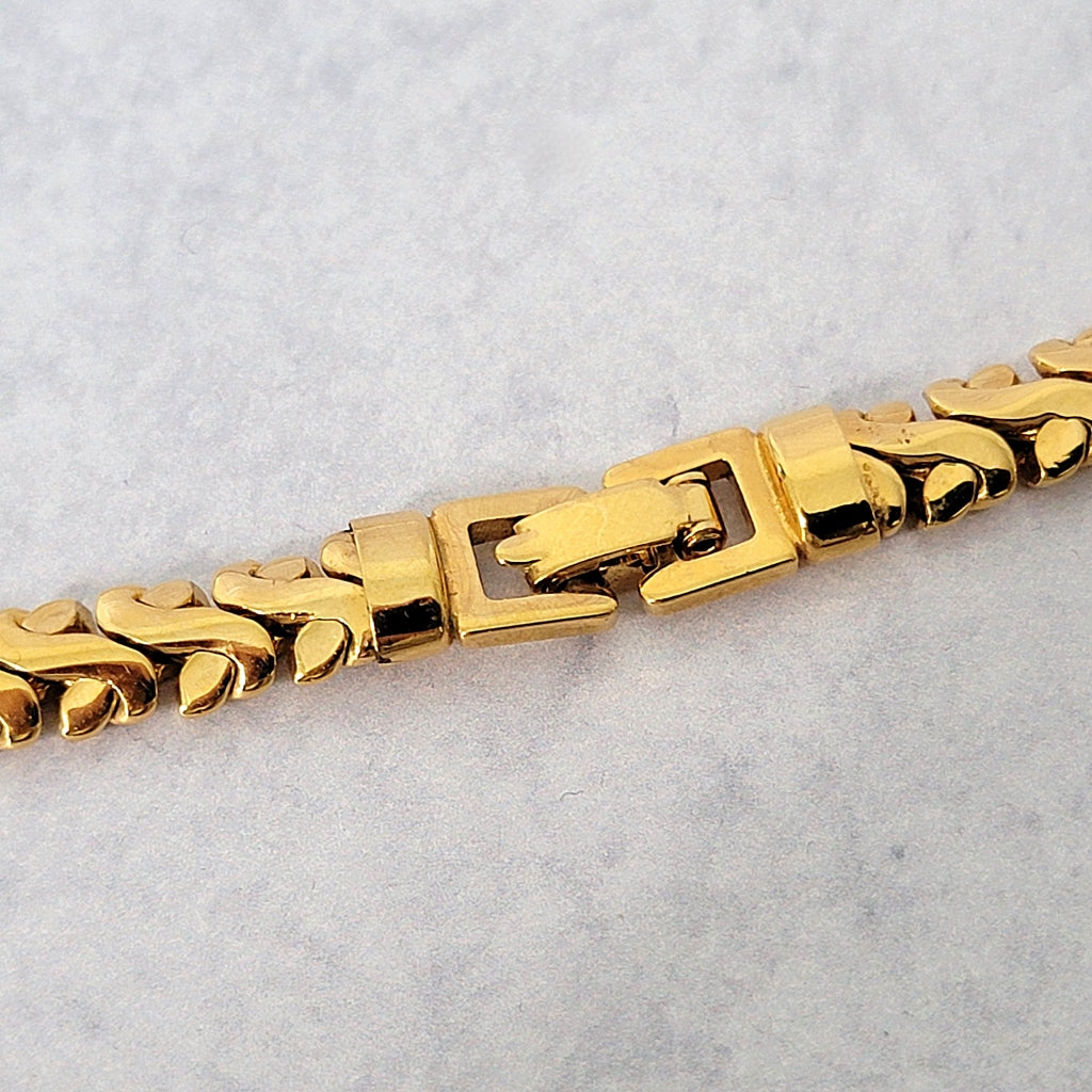Necklace clasp on a gold tone chain.