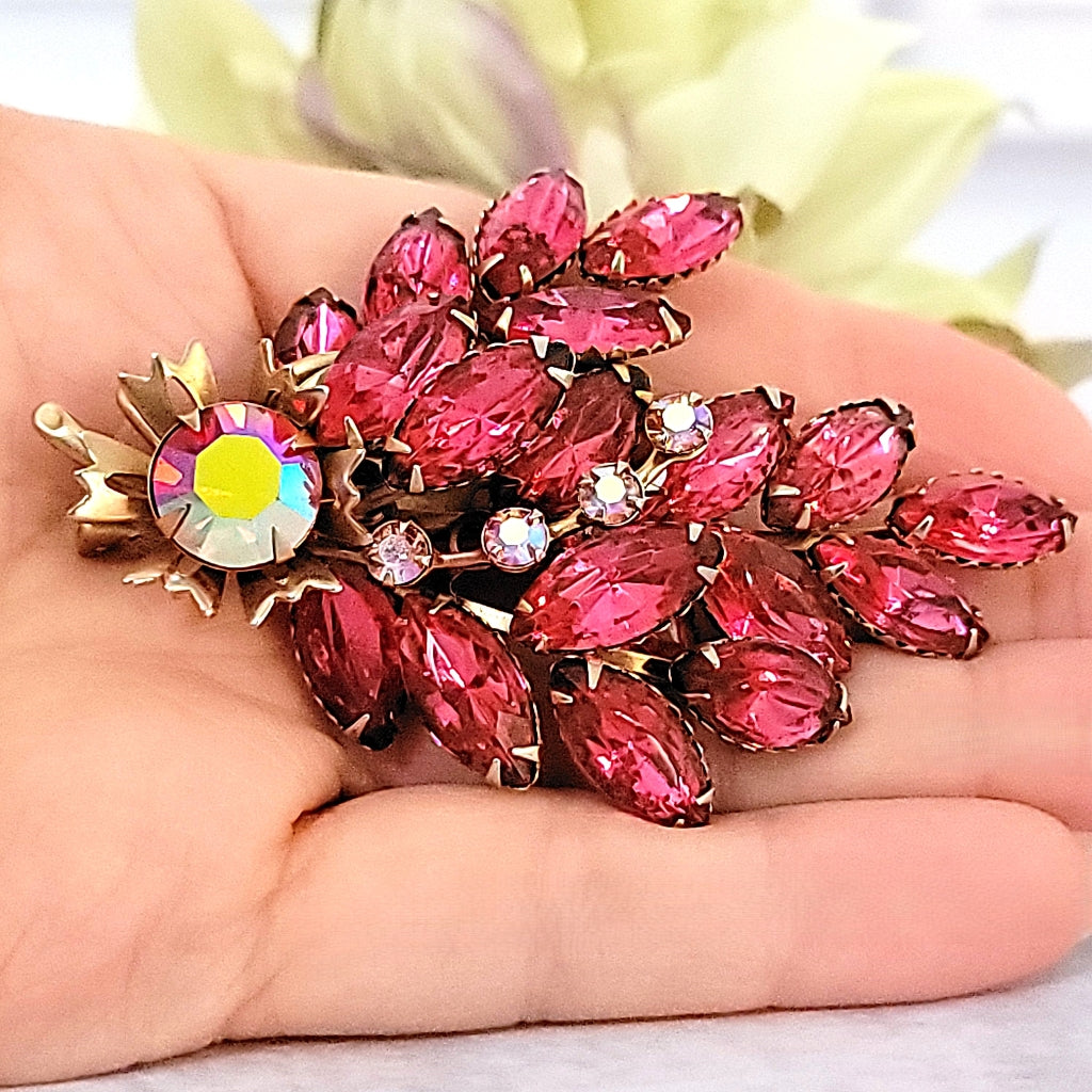 Vintage pink brooch in hand.