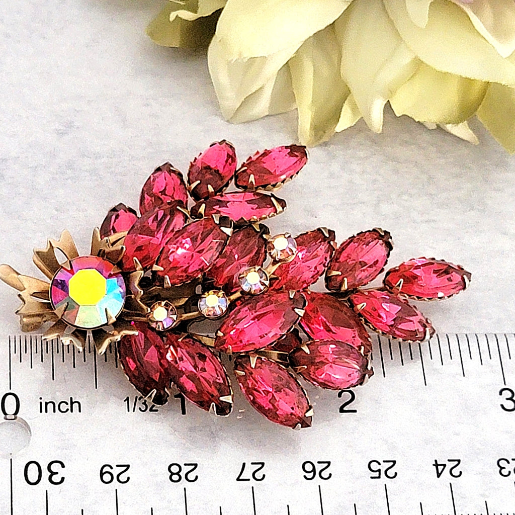 Pink rhinestone pin next to a ruler.