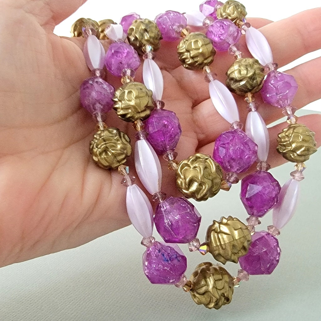 Purple and gold vintage lucite necklace beads in hand.