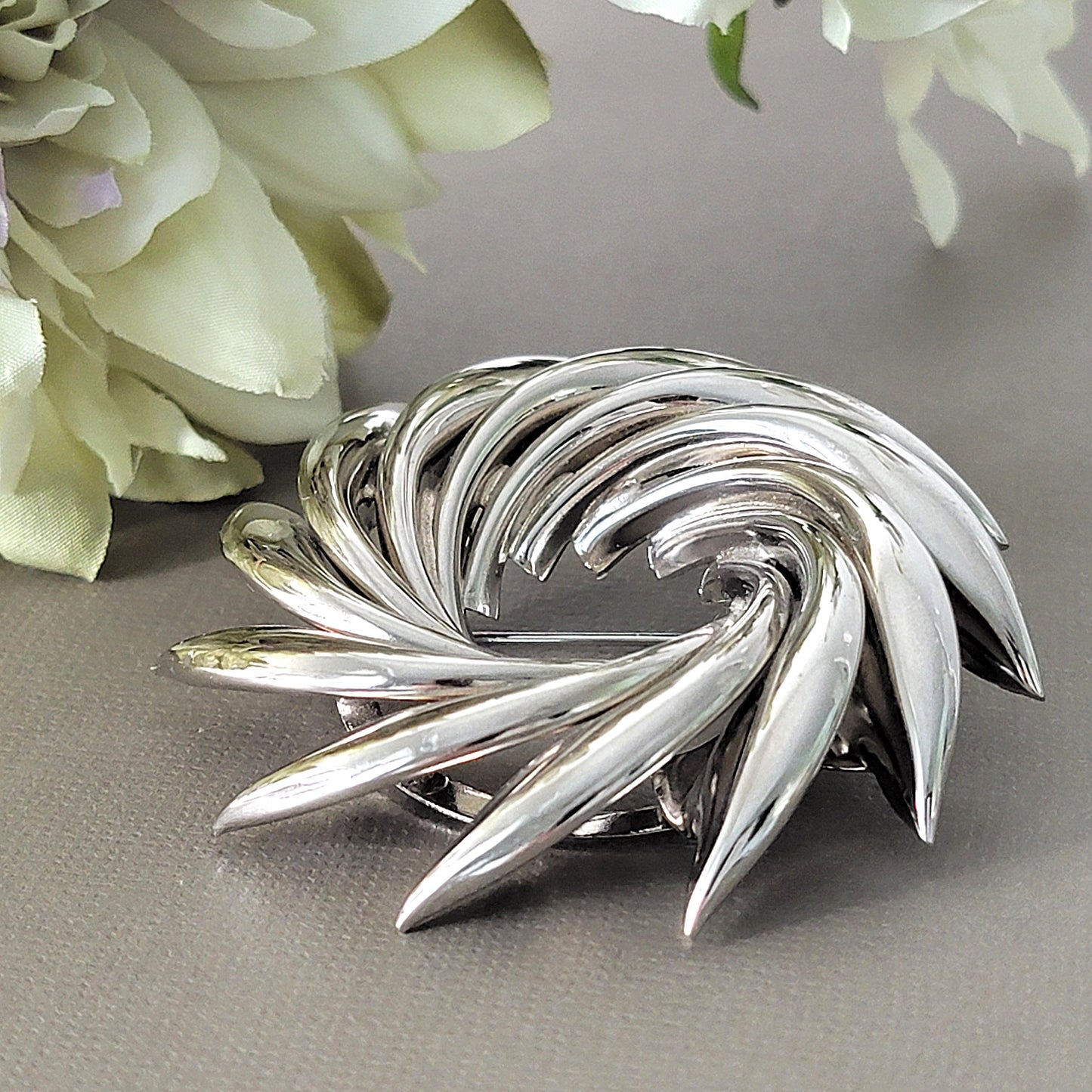 Detail silver tone spike wreath brooch.