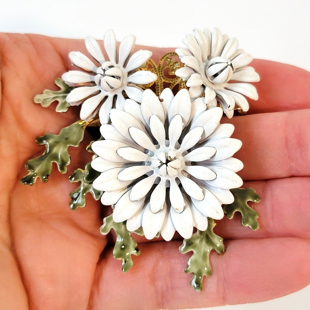 White flower pin in hand.