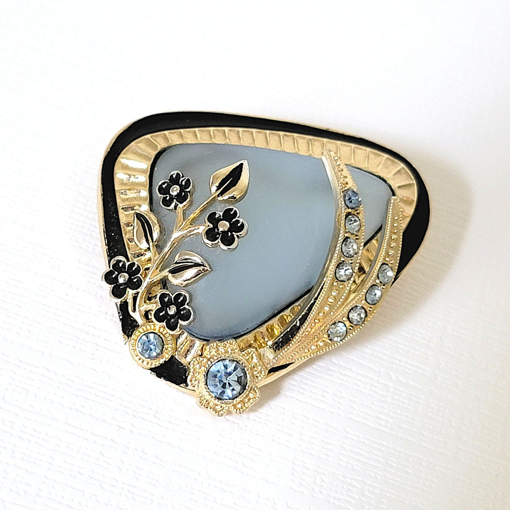 Vintage midcentury style rhinestone brooch with blue frosted glass and black enamel flowers.