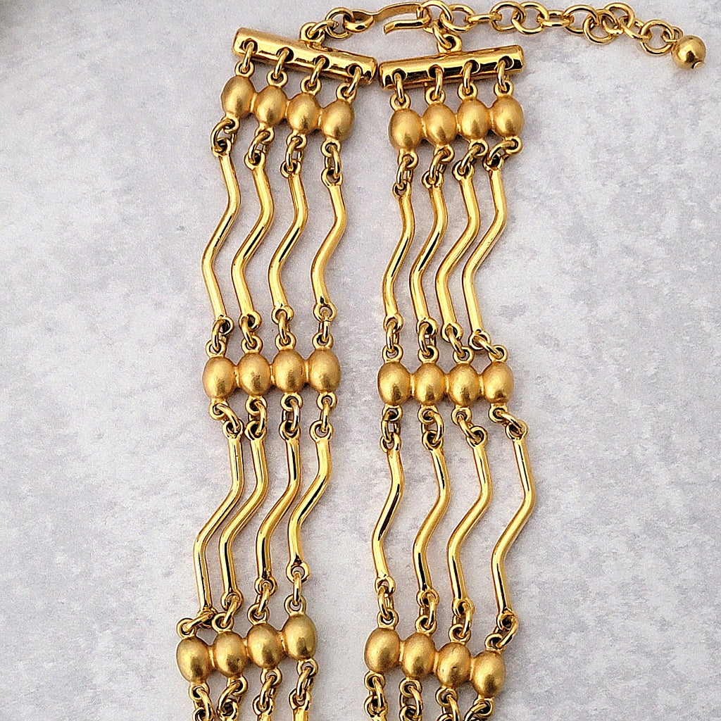 Gold wavy bar style necklace links.