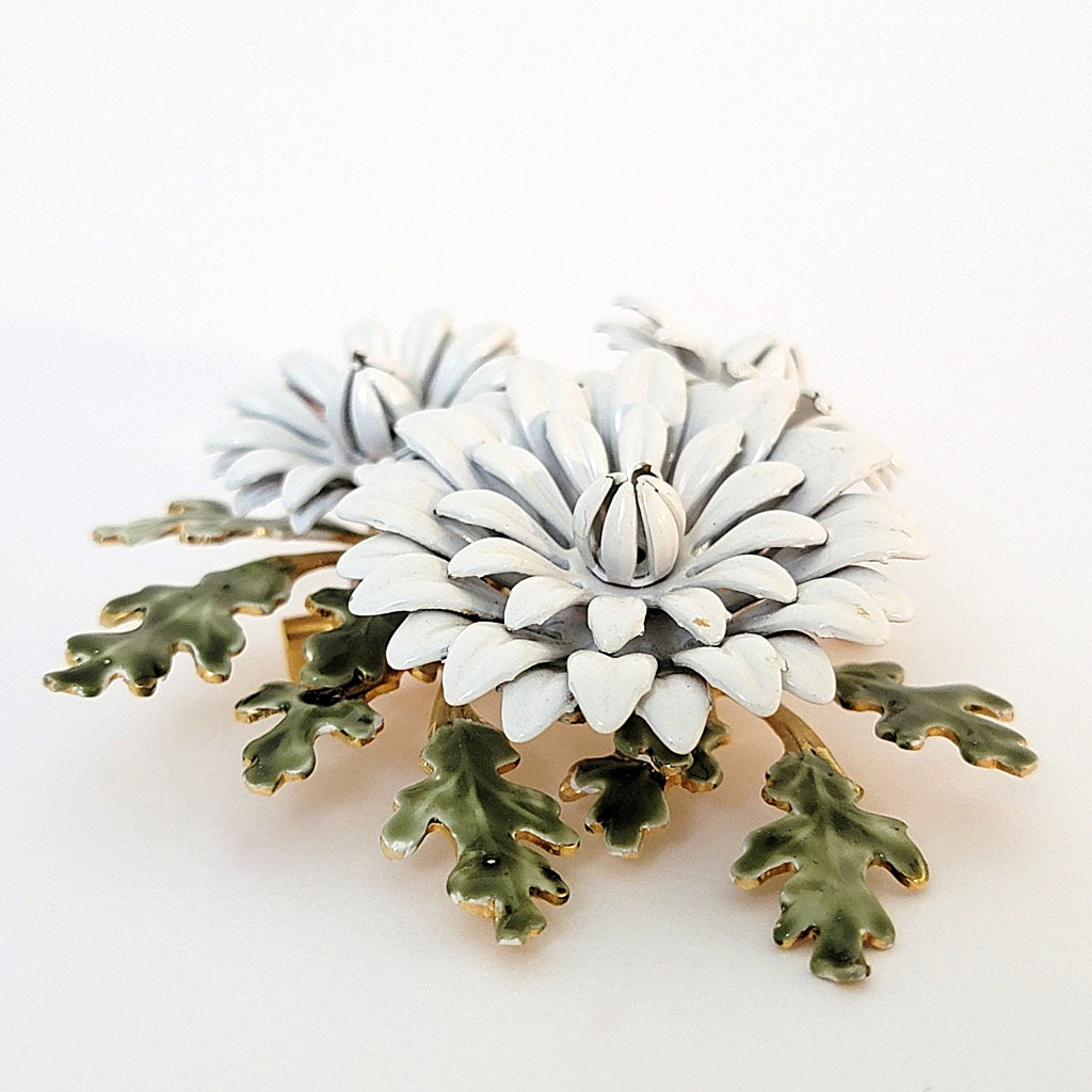 Layers of a white vintage enamel flower brooch.