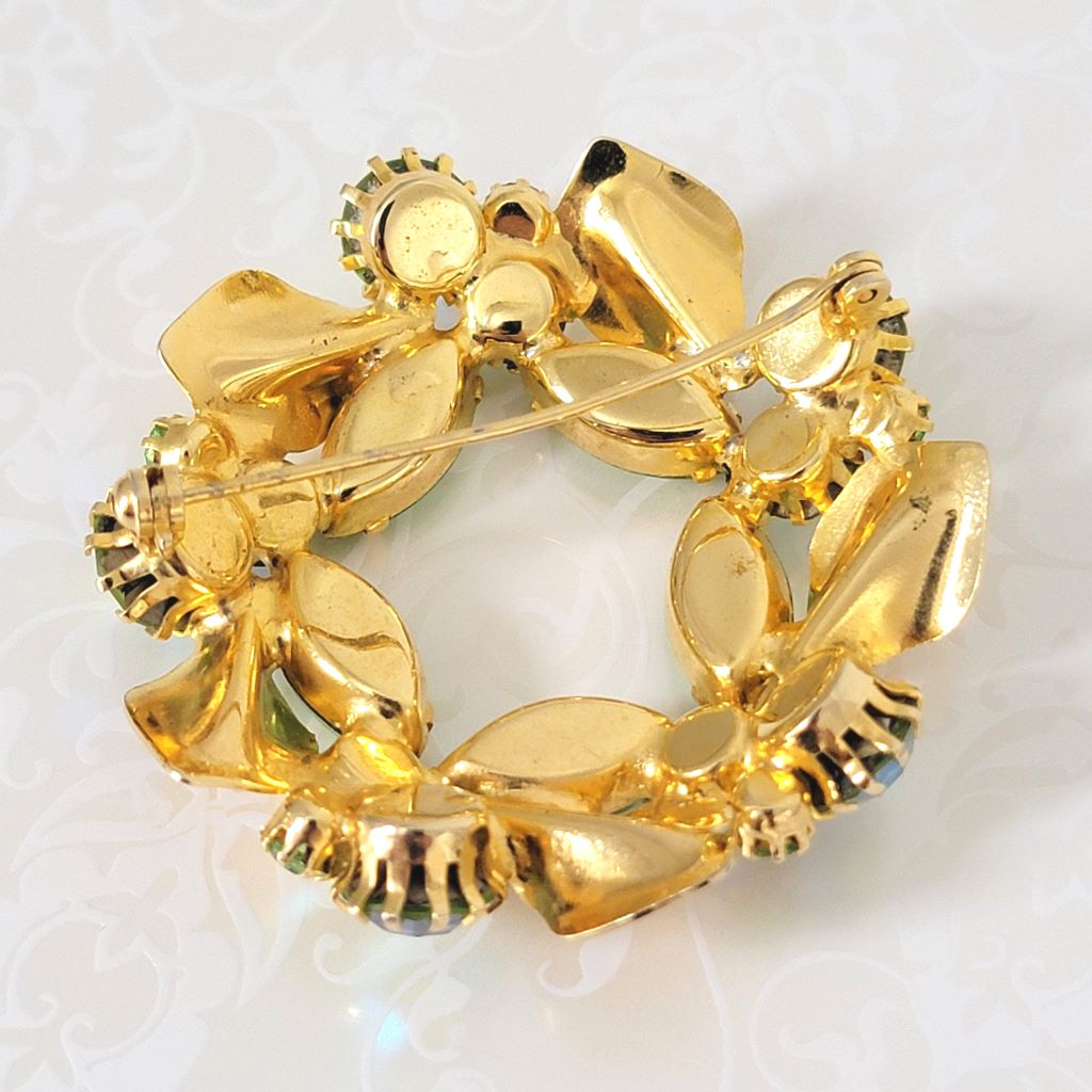 Back view of green rhinestone wreath pin, showing clasp.