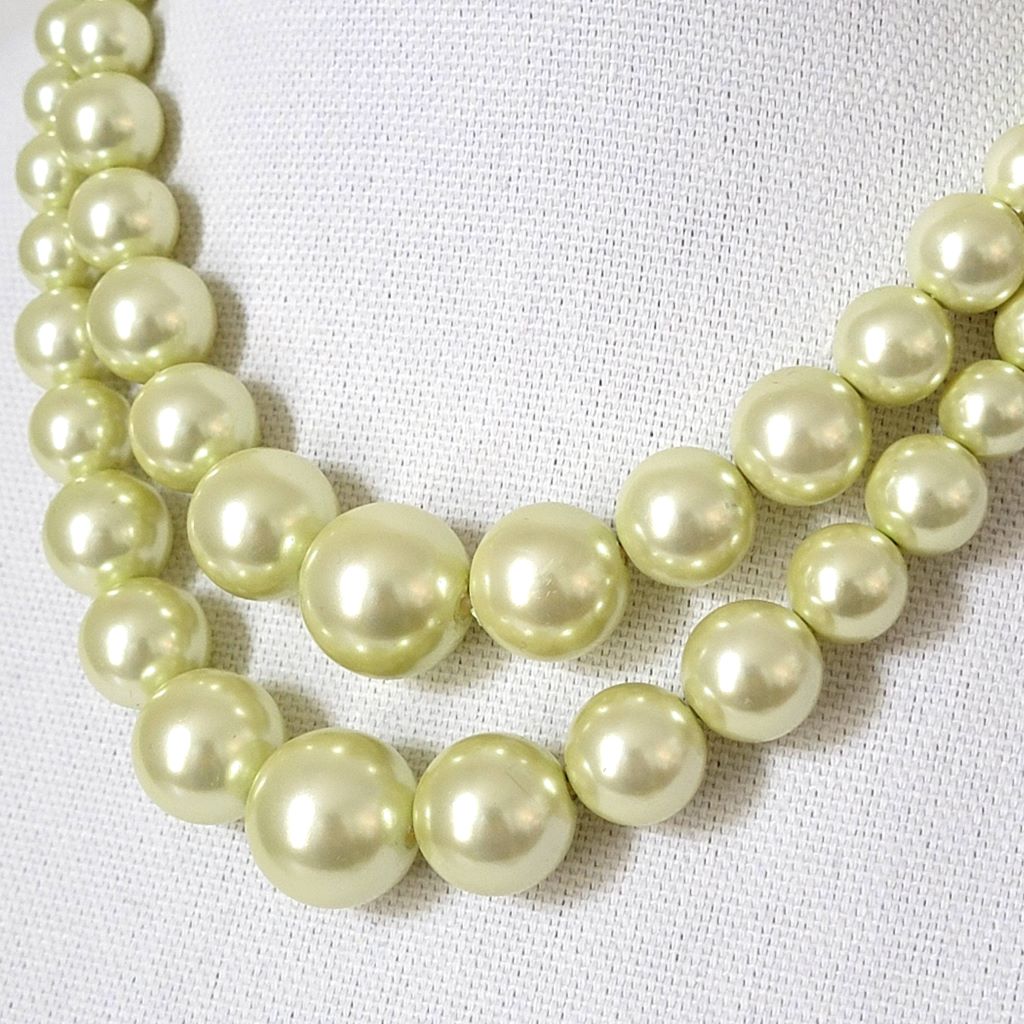 Closeup view of a two strand yellow vintage faux pearl choker.