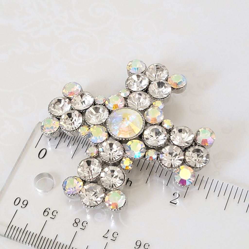 Large rhinestone cross pendant brooch, next to a ruler.