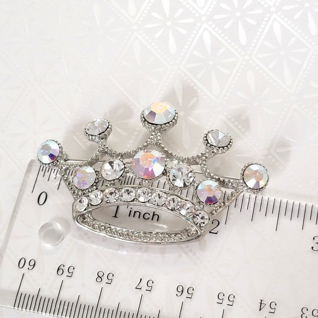 Rhinestone crown brooch, next to a ruler.