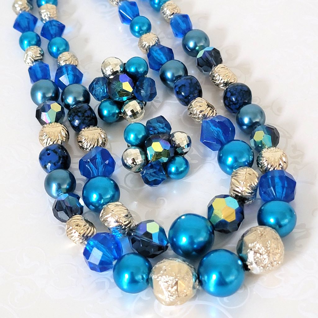 Vintage blue faux pearl choker and clip on earrings set, 50s style, with silver tone accents. Closeup view.