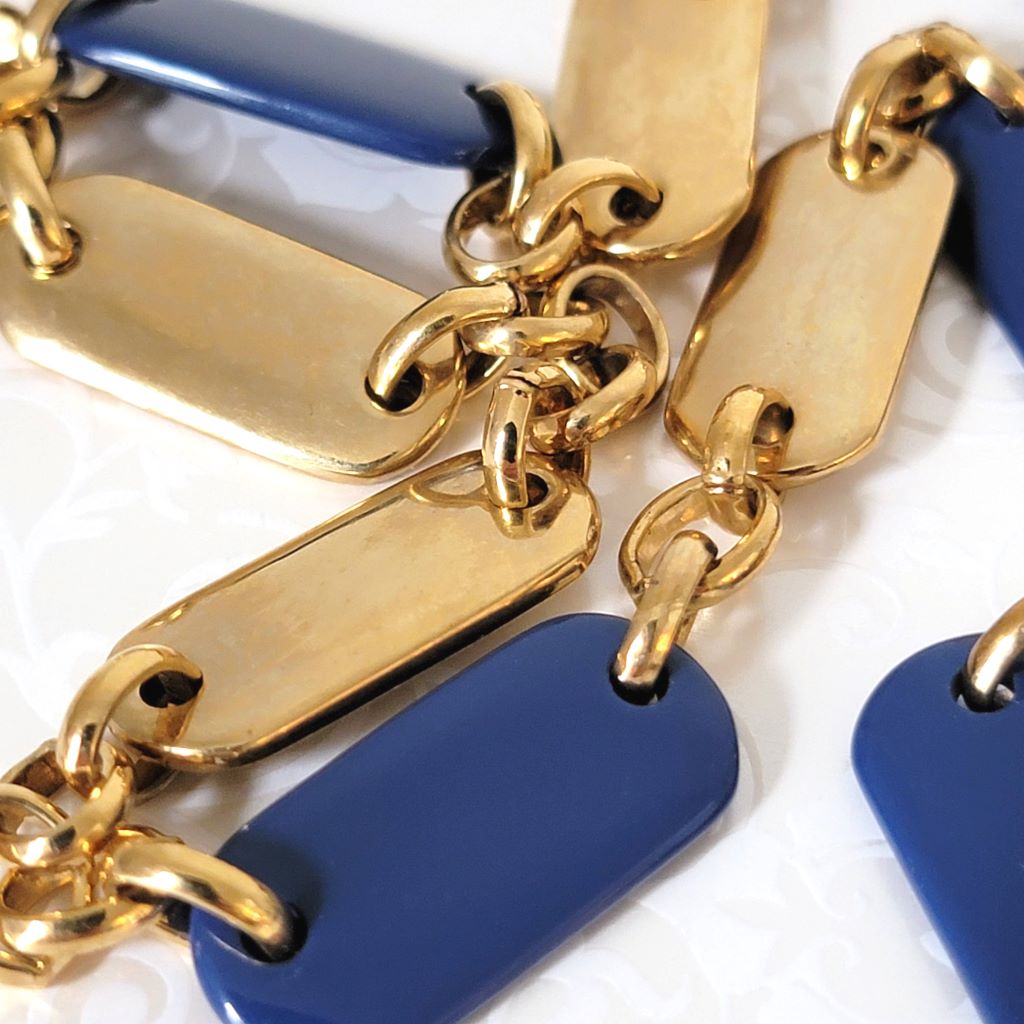 Closeup view of Liz & Co. long gold tone chain necklace, with navy blue accents.
