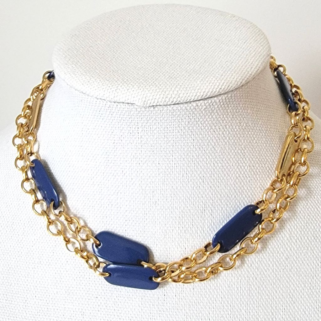 Liz & Co. long gold tone chain necklace, with navy blue accents, shown doubled, on a display stand.