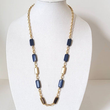 Liz & Co. long gold tone chain necklace, with navy blue accents, shown on a display stand.