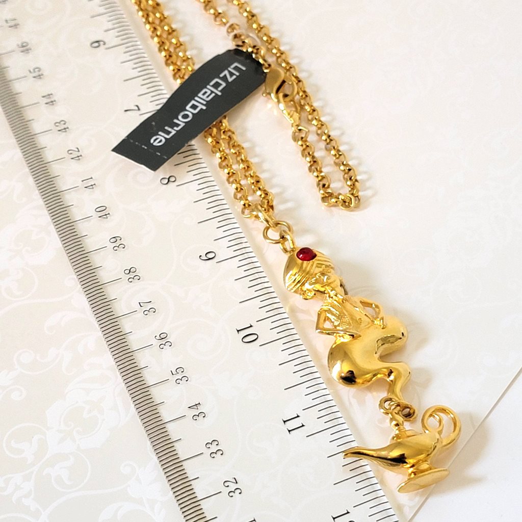 Liz Claiborne genie and bottle pendant necklace, next to a ruler.