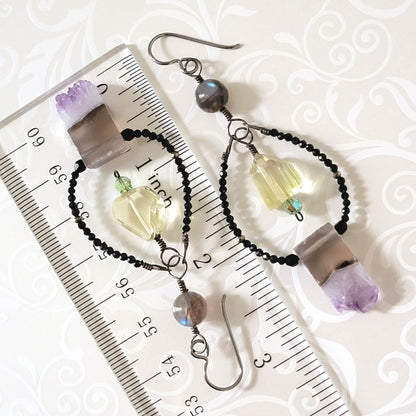 Long purple gemstone earrings, shown next to a ruler