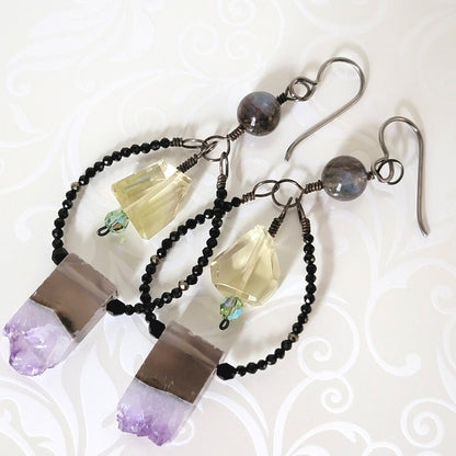 Close-up view of purple and yellow gemstone dangle earrings.
