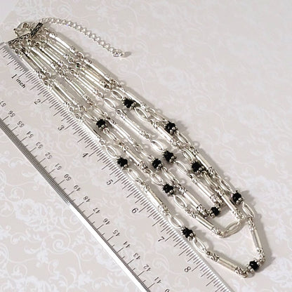 Avon three strand, silver tone necklace, shown next to a ruler.