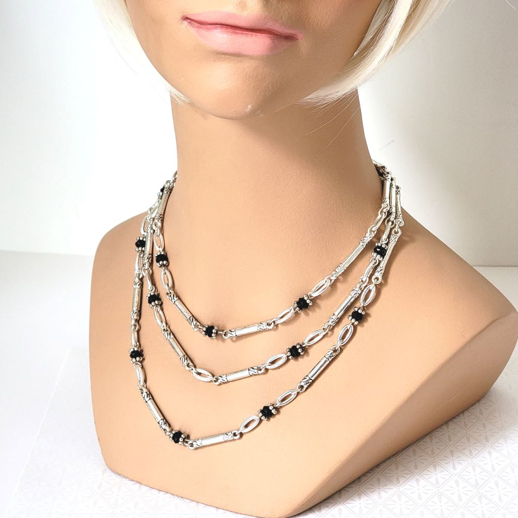 Avon three strand, antiqued silver tone necklace, with black bead accents. Shown on a mannequin.