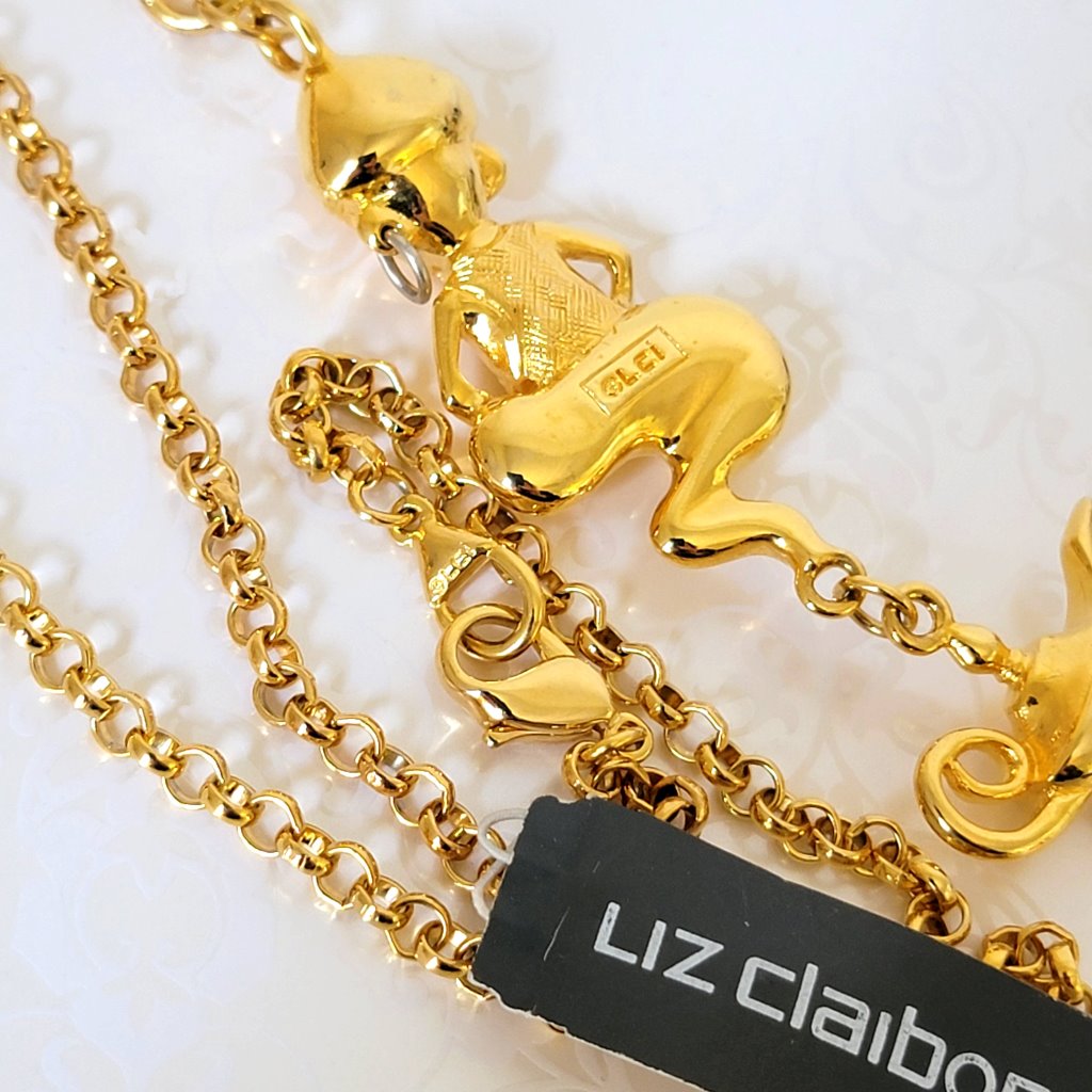 Back view of a Liz Claiborne genie pendant necklace, showing signature marks.
