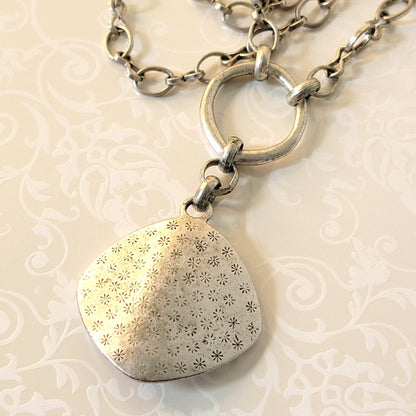 Back view of an antiqued silver tone pendant, by Premier Designs.