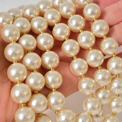 Big faux pearl beads in hand.