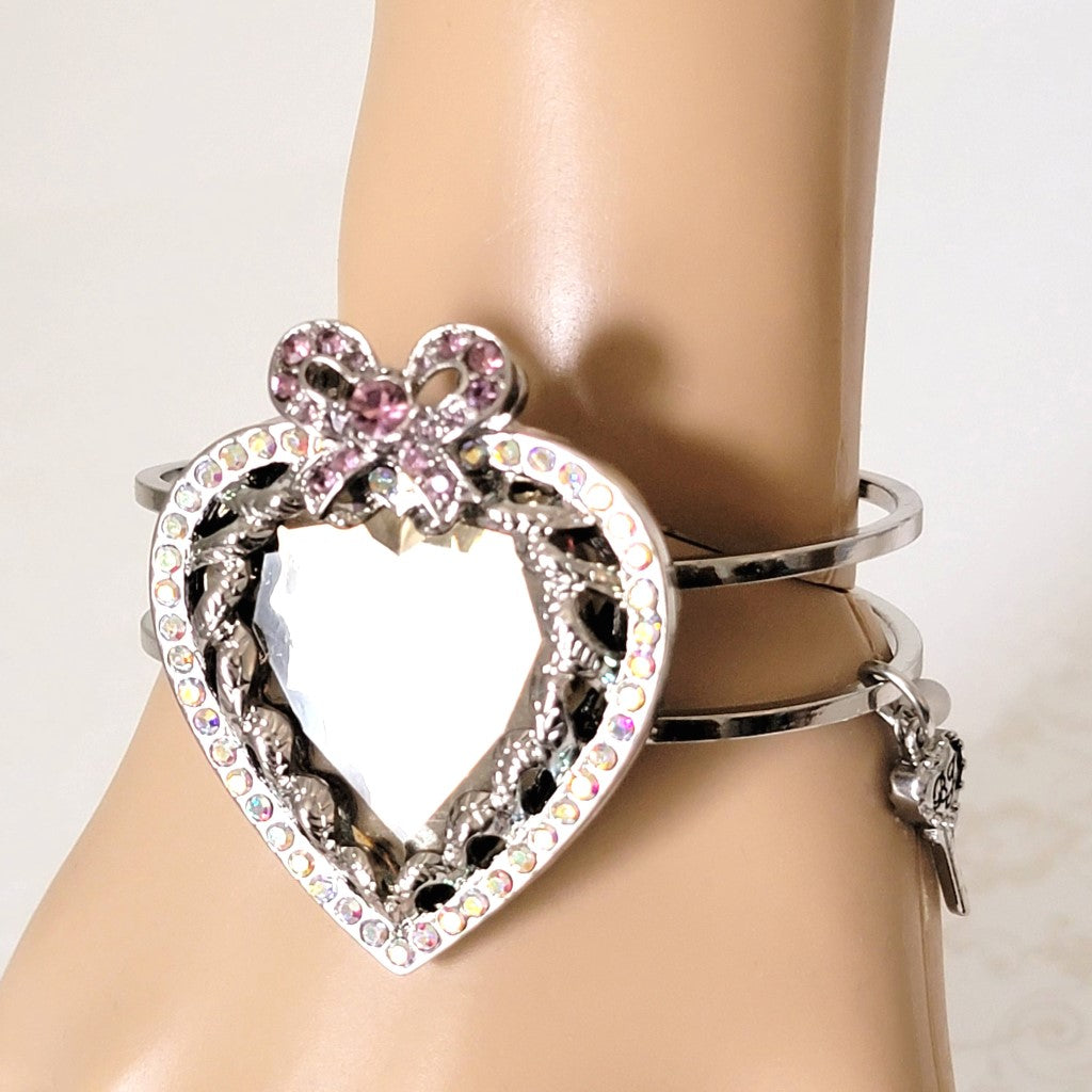 Betsey Johnson rhinestone mirror heart bracelet, with bow, shown on wrist.