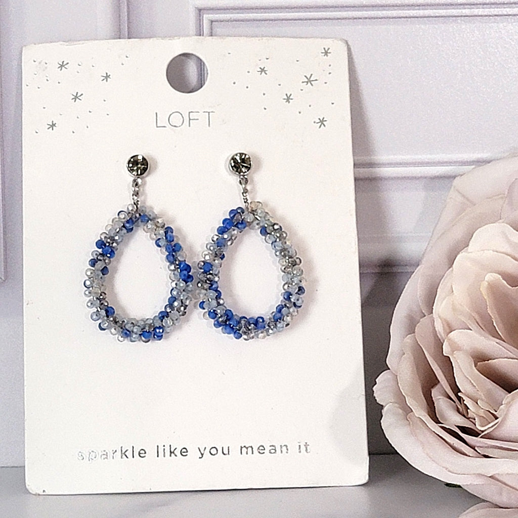 Blue beaded dangle earrings on card.