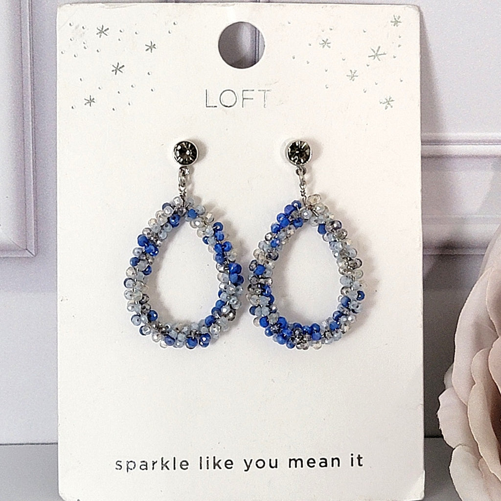 Blue beaded dangle earrings on card.