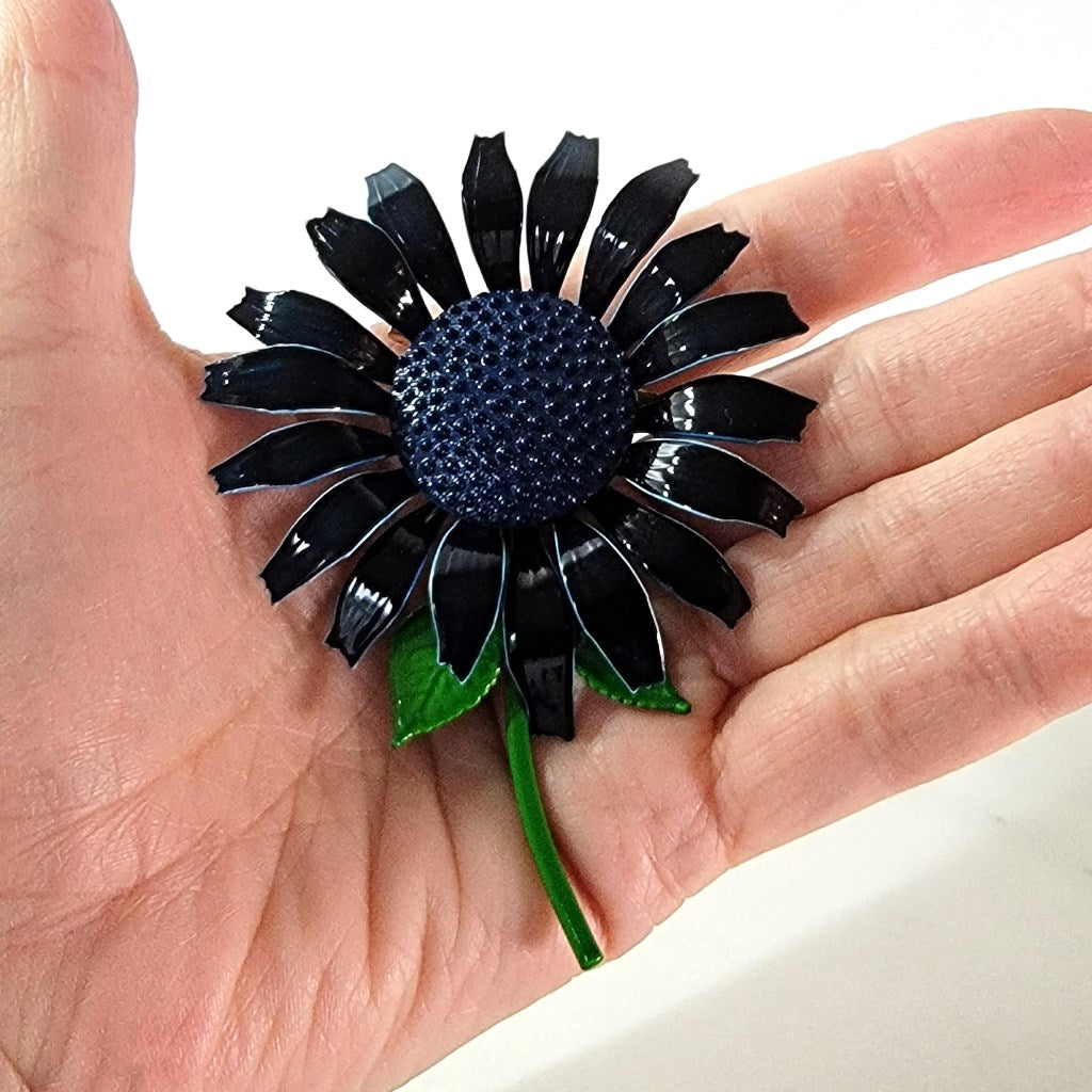 Enamel flower pin in hand.