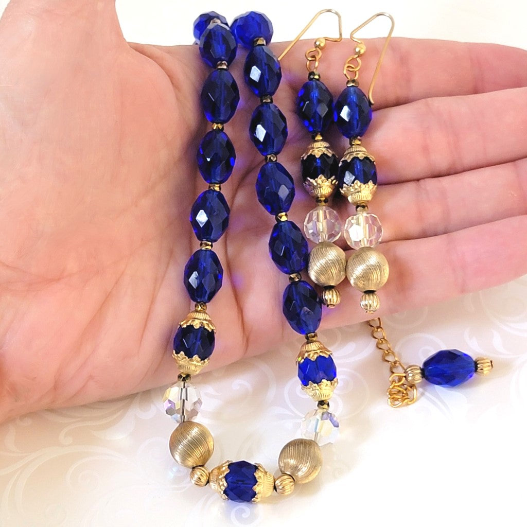 Vivid blue glass necklace and dangle earrings set, shown in hand, for size comparison.