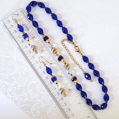 Handmade blue glass necklace and earrings jewelry set, shown next to a ruler.