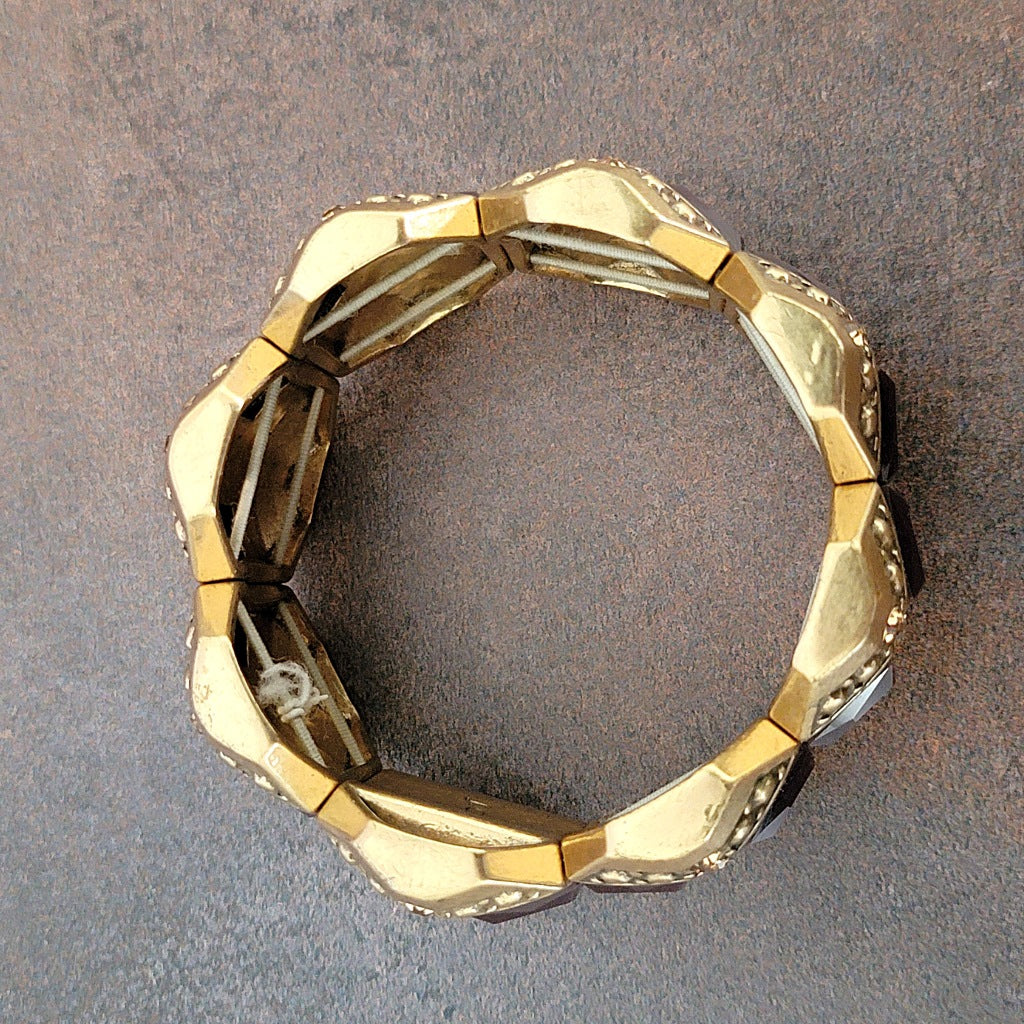 Bottom of a gold tone stretch bracelet.
