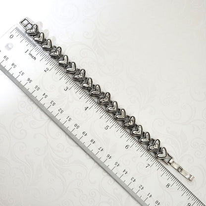 Antiqued silver plated Brighton hearts bracelet, shown next to a ruler.