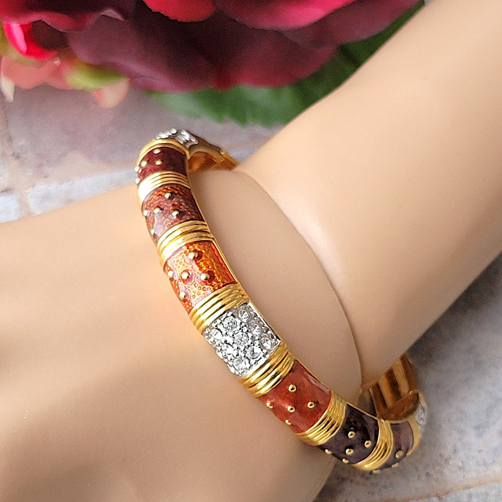 Brown enamel and rhinestone bracelet on a wrist.