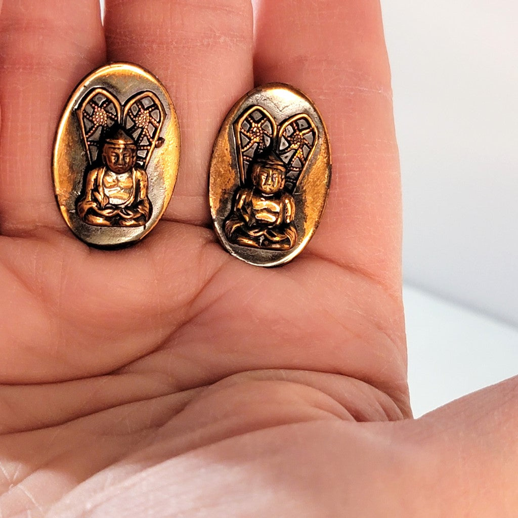 Buddha earrings in hand.