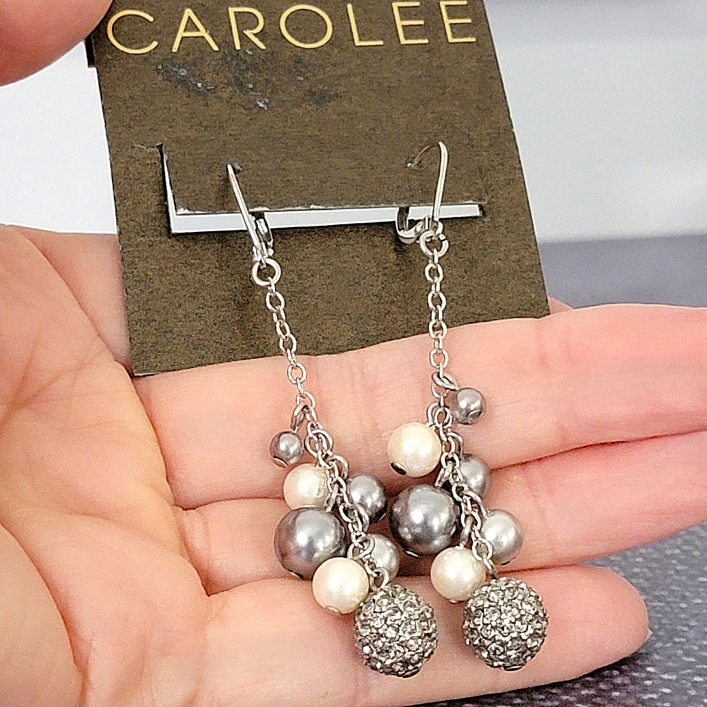 Carolee faux pearl dangle earrings in hand.