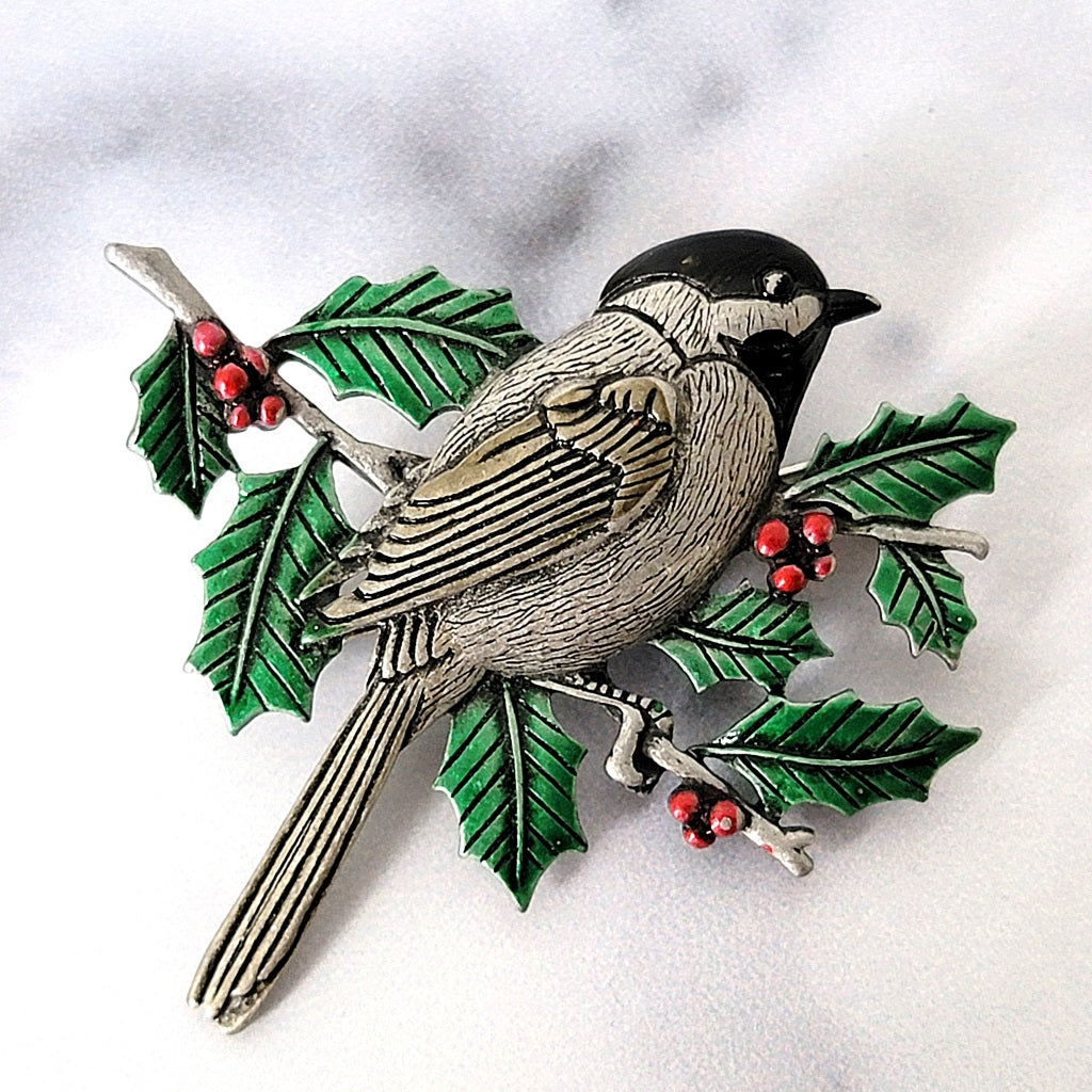 Bird brooch with green enamel leaves.